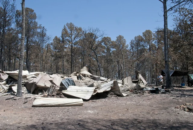 A Bastrop County resident stands looking at the burned remains of his home after the September 2011 Bastrop County Complex Fire swept through the area
