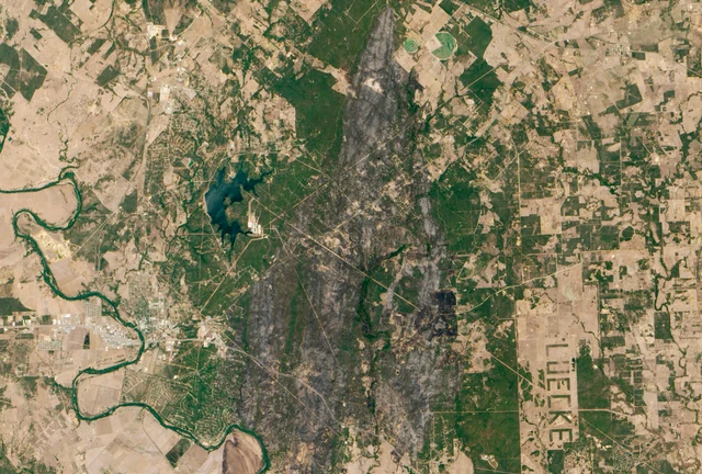 Satellite image of the dark burn scar left across the Lost Pines east of Bastrop, Texas, by the September 2011 Bastrop County Complex Fire