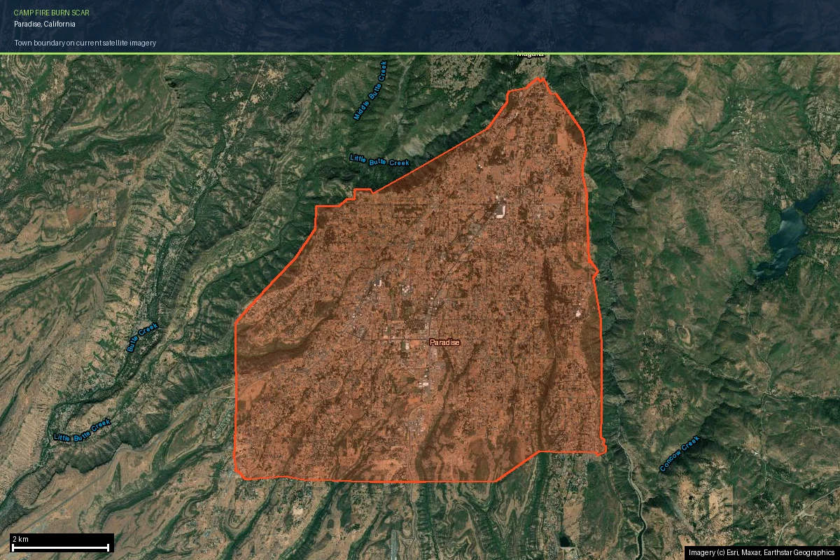The Town of Paradise boundary outlined on current satellite imagery, showing the pale grey-brown Camp Fire burn scar filling the town's ridge-top footprint while dark green unburned forest remains in the canyons on either side