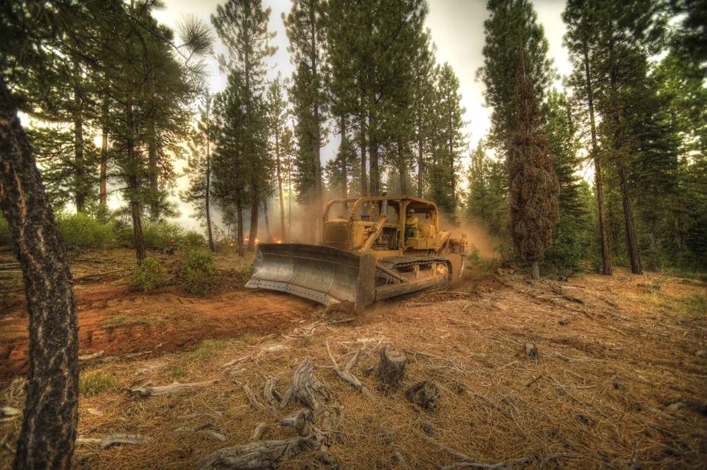 Barry Point Fire (2012) in Modoc County, California - A dozer operator constructs a fire break on the California side of the Barry Point Fire. Hand and engine crews conduct mop-up oper