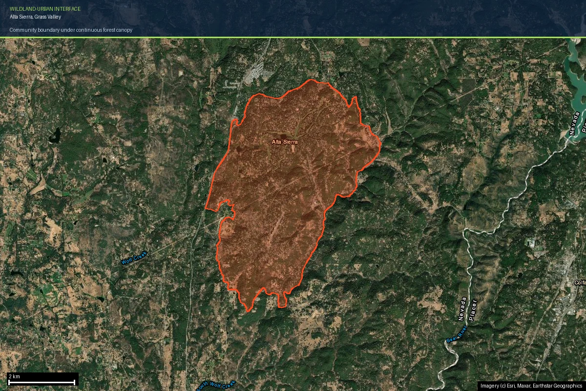 The Alta Sierra community boundary outlined on current satellite imagery south of Grass Valley, California, showing an unbroken dark green forest canopy inside and outside the boundary with only faint road lines revealing the subdivision