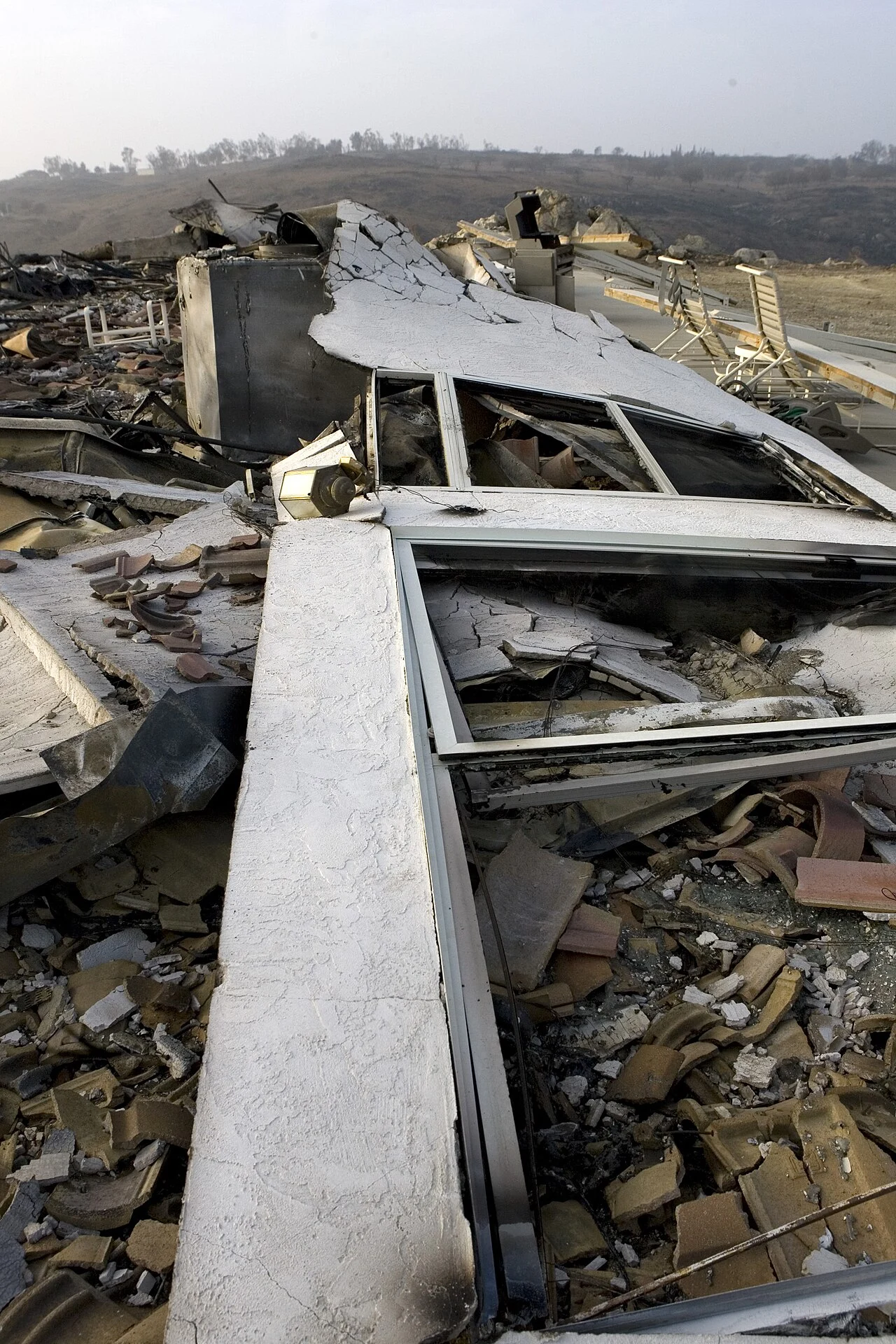A completely destroyed home reduced to collapsed rubble and roof tiles in Ramona, California, after the 2007 Witch Creek Fire