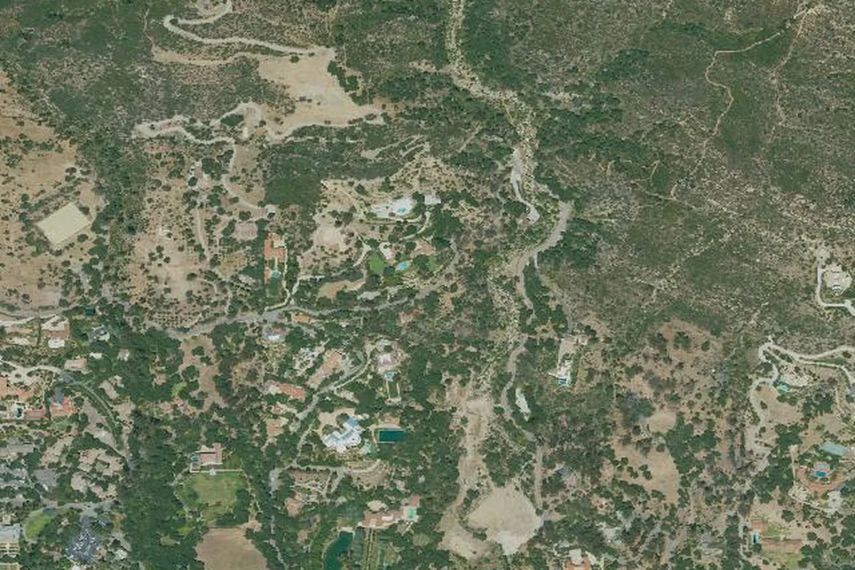 Satellite imagery of Montecito, California, showing large wooded estates threaded through canyons at the base of the steep Santa Ynez Mountains front range