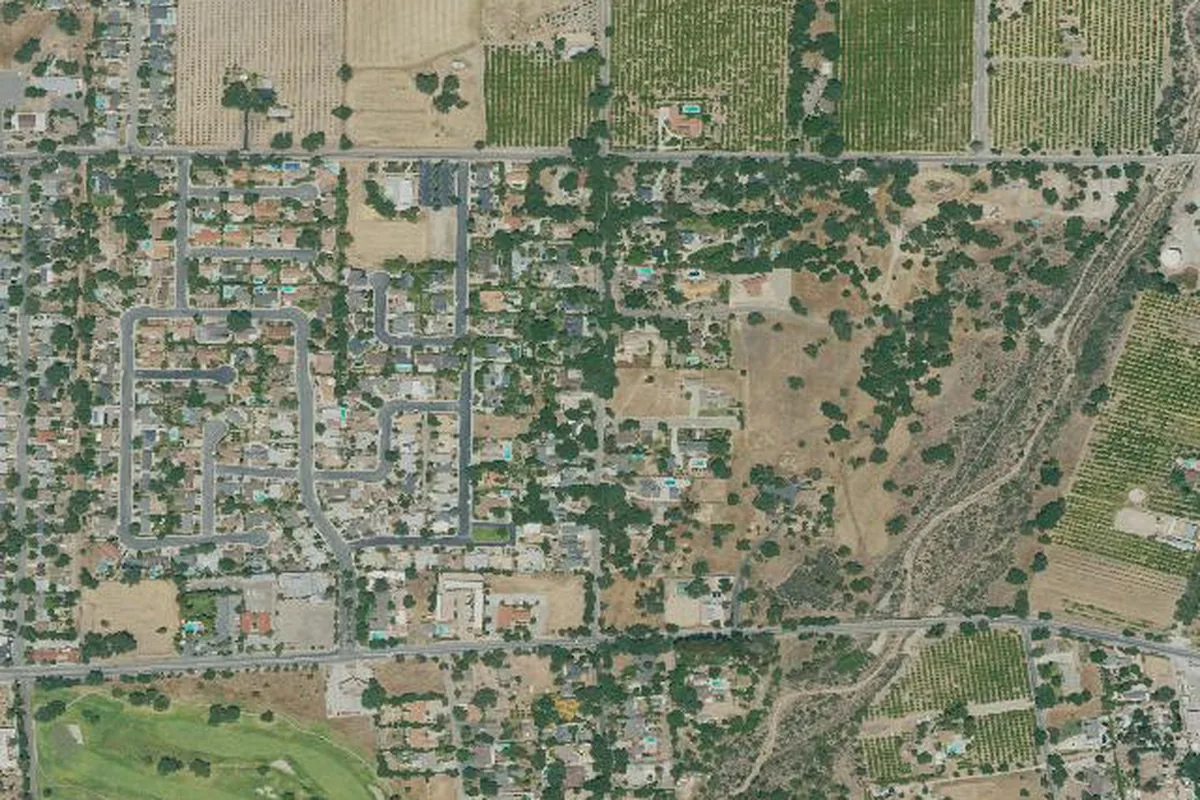 Satellite imagery of the Ojai townsite in Ventura County, showing the grid of streets and orchards on the valley floor meeting chaparral foothills on the north edge