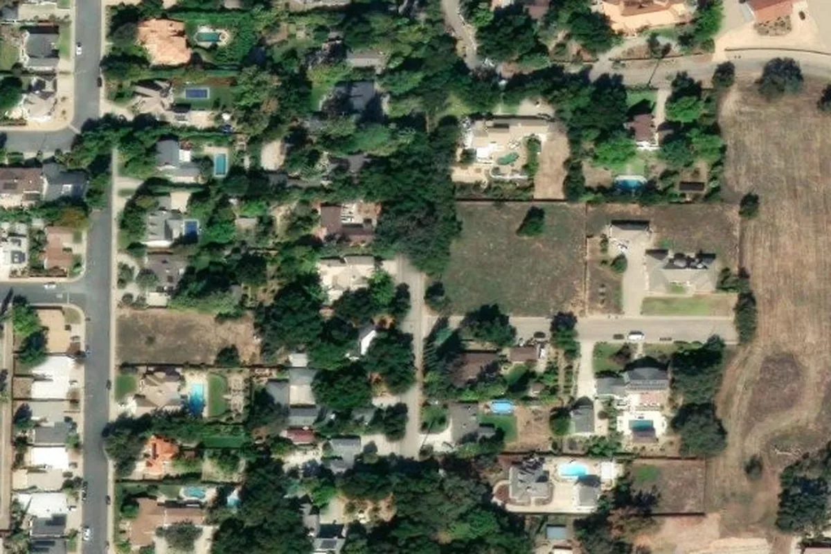 High-resolution satellite imagery of a residential parcel on Gridley Road, Ojai, showing homes set among mature oaks and ornamental landscaping on the valley floor below the chaparral foothills